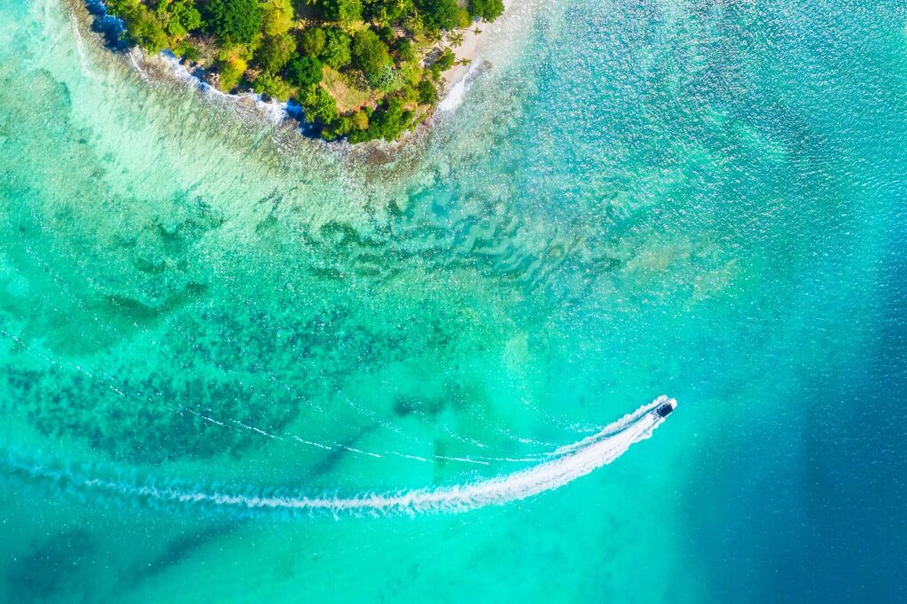 Aerial drone view of beautiful caribbean tropical island Cayo Levantado beach with palms and boat. Bacardi Island, Samana, Dominican Republic. Vacation background