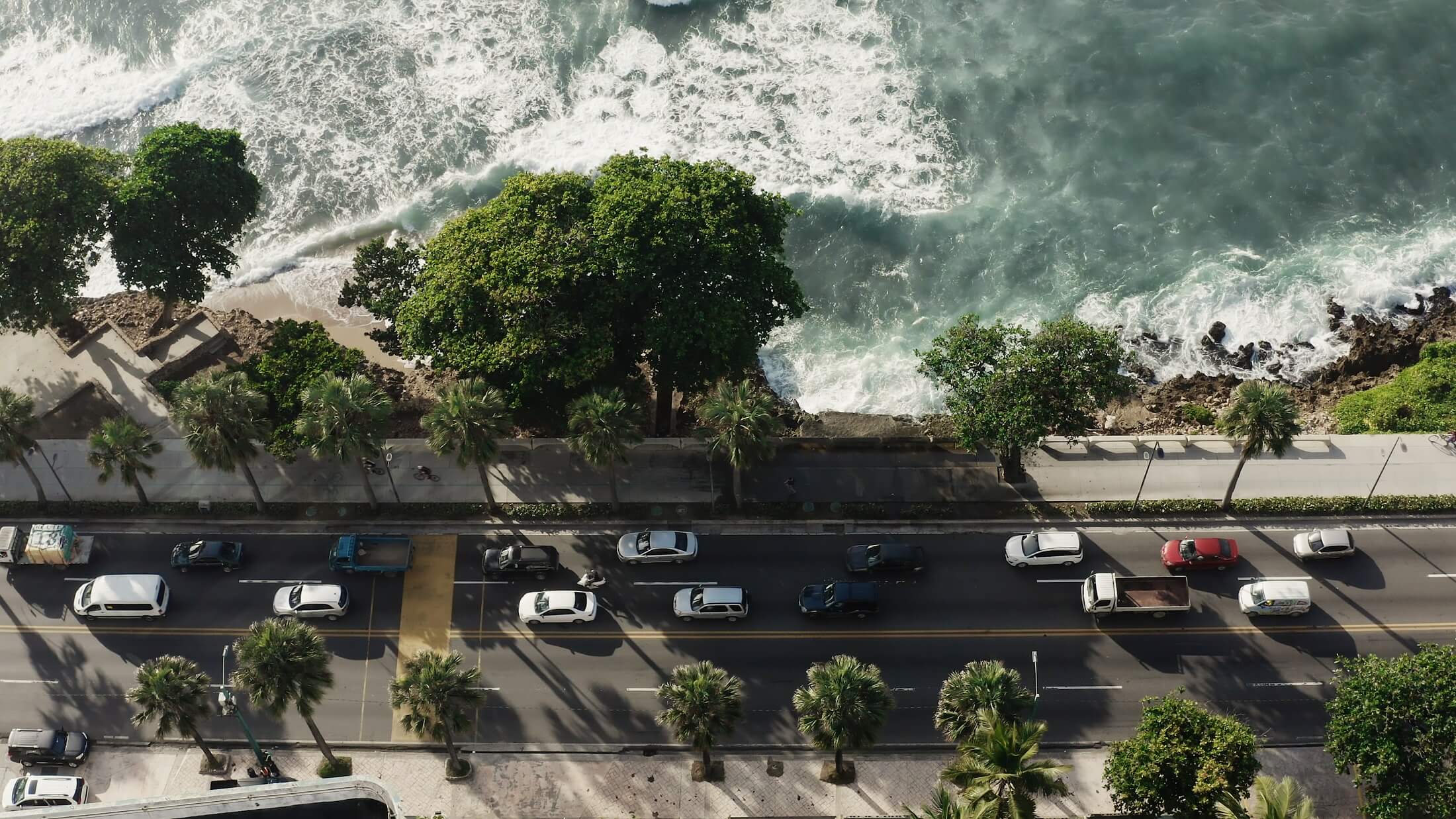 Embankment of the Dominican capital Santo Domingo. Cars on the road by the ocean. The road along the sea. Beautiful waves and transport. City by the ocean