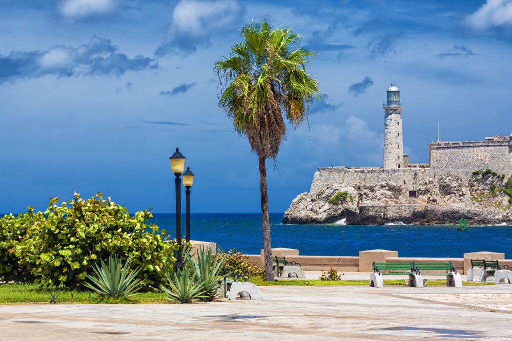 The castle of El Morro, a symbol of Havana, and a nearby romantic park on a day with a beautiful sky