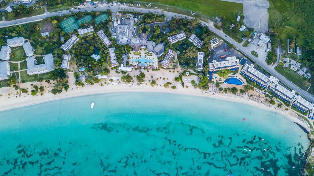 Aerial Image of Negril Jamaica featuring beach, sunset, clear water, vacation destination and serenity