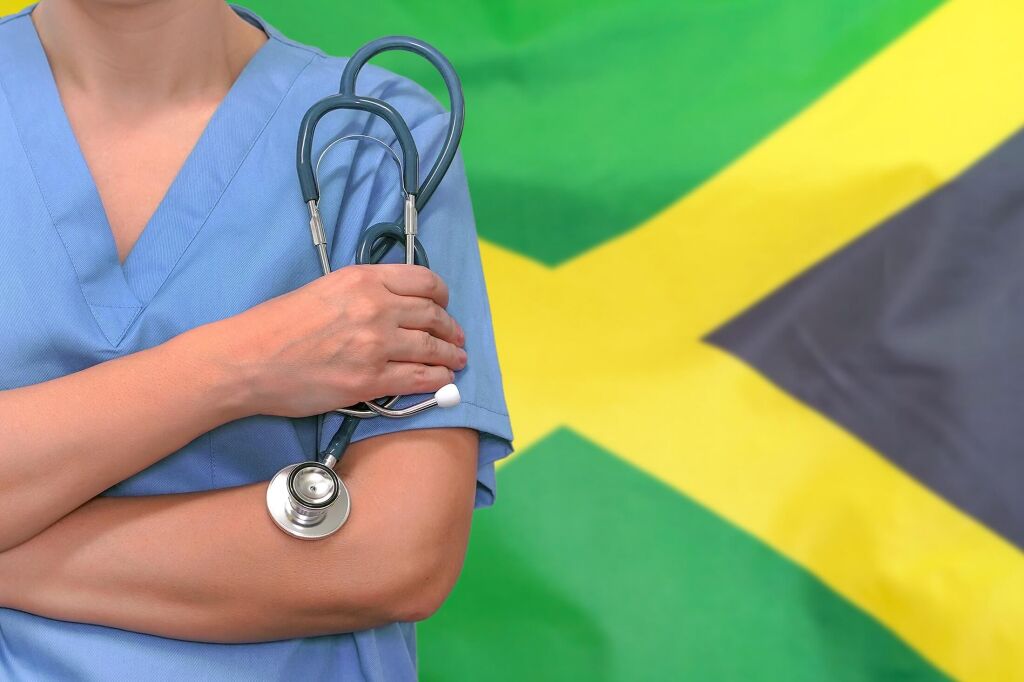 Female surgeon or doctor with stethoscope in hand on the background of the Jamaica flag. Surgery concept in Jamaica