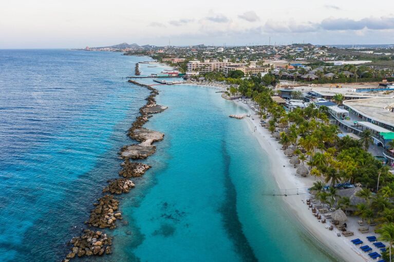 Aerial view of coast of Curacao in the Caribbean Sea with turquoise water, cliff, beach and beautiful coral reef around Mambo Beach