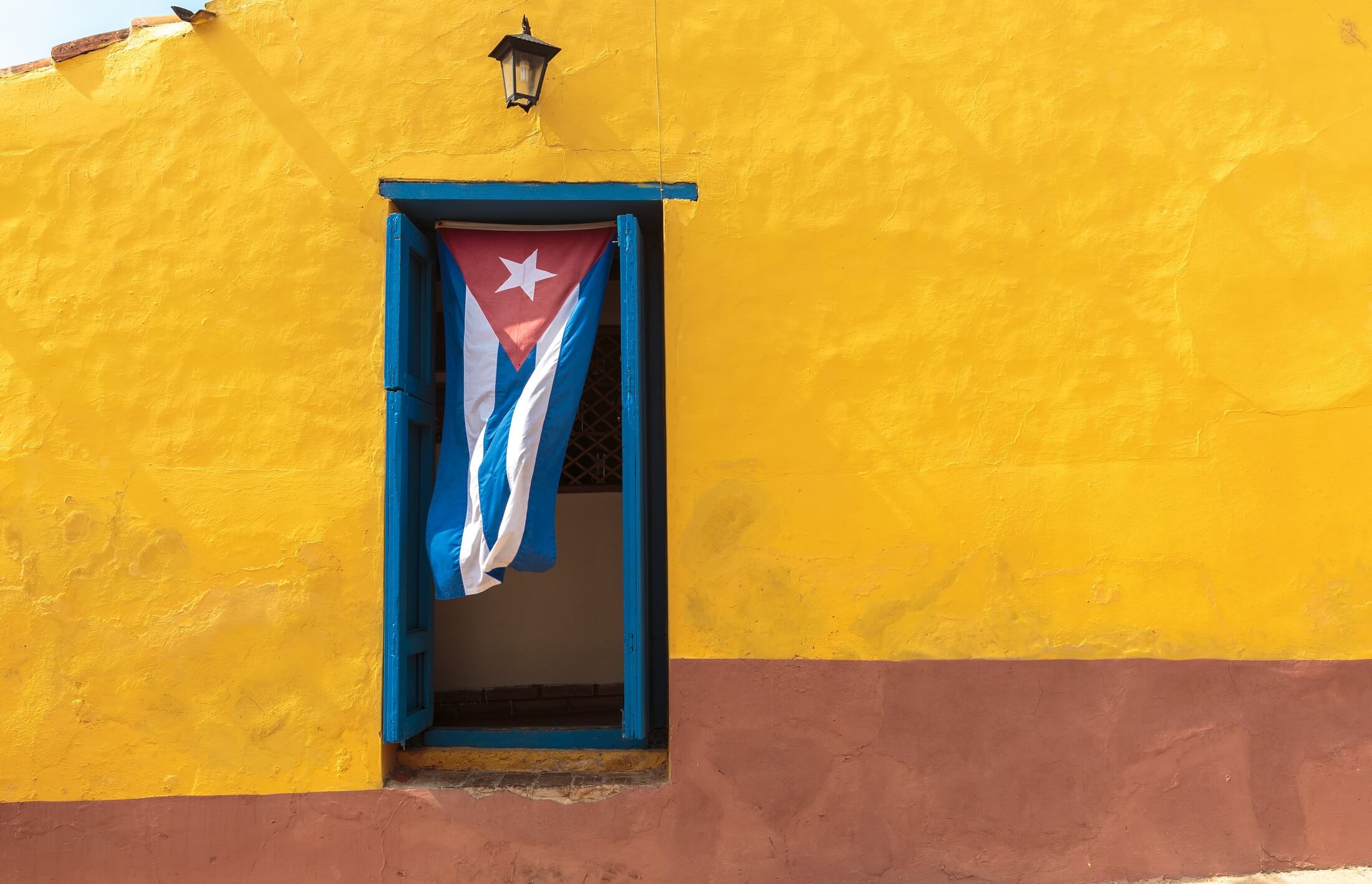 Kubańska flaga wisząca na drzwiach w Trinidad, Kuba