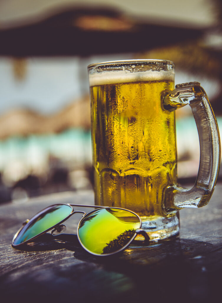 delicious refreshing cold mug of beer and sunglasses in a sunny day at the caribe,