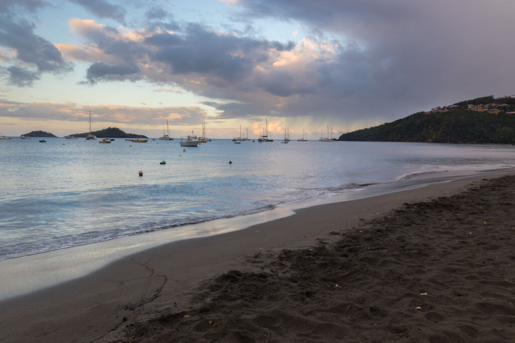 Early morning and sunrise at Malendure beach in Guadeloupe, Caribbean. Place famous for its dark sand and great diving conditions at nature reservation "Reserve Cousteau"