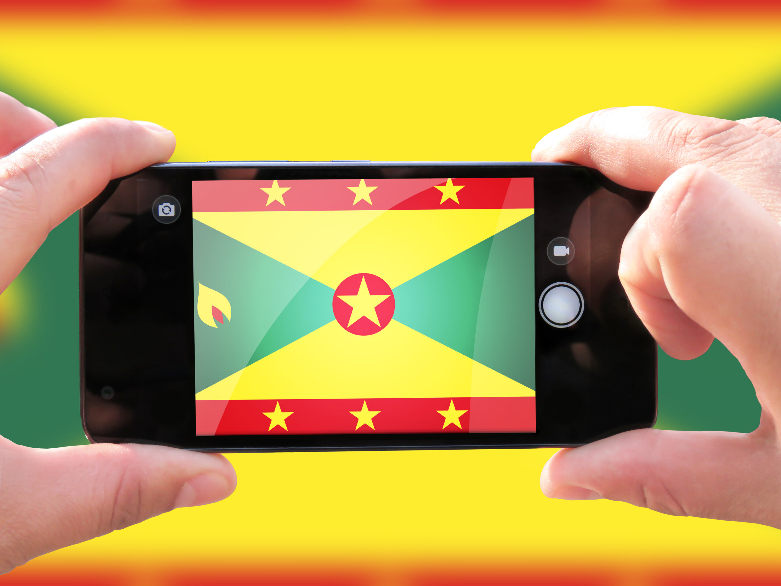 The concept of tourism and travel. The hands of men make a telephone photograph of the flag of Grenada. On the smartphone close-up image of the flag. Photos for social networks, blogs, instagram.