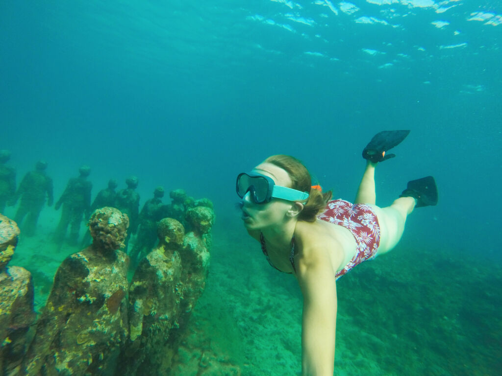 Young girl free diving with goggles and pins in Grenada, underwater sculpture park of St. George's, underwater treasures in the ocean