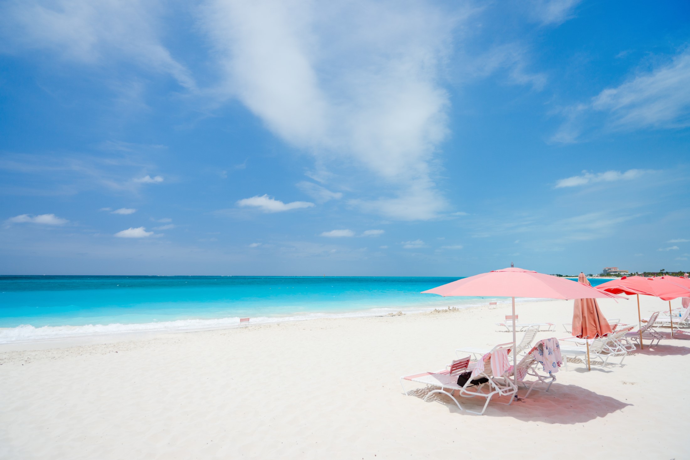 Różowe parasole na pięknej plaży na wyspie Providenciales w Turks i Caicos
